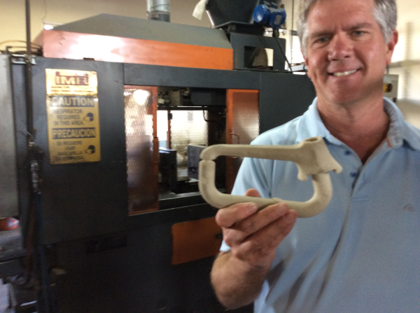 Geoff Escalette is holding up a sand casting.